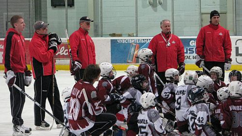 Jaunie hokejisti cītīgi klausās treneru stāstīto