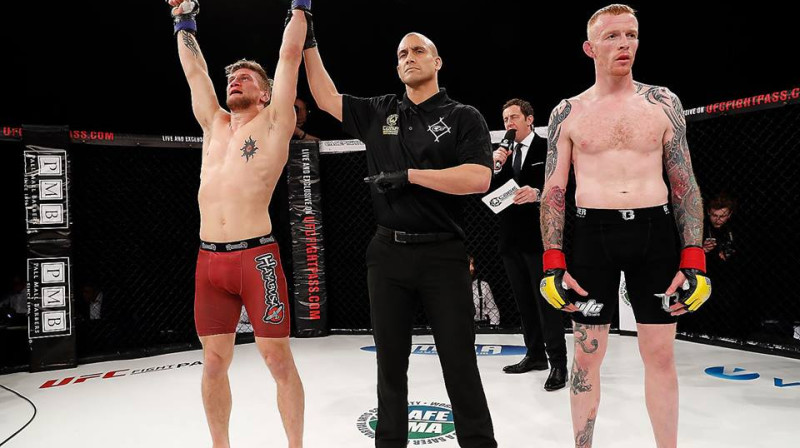 Aleksandrs Jakobsens (no kreisās) pēc uzvaras pār Timu Vaildu
Foto: Cage Warriors