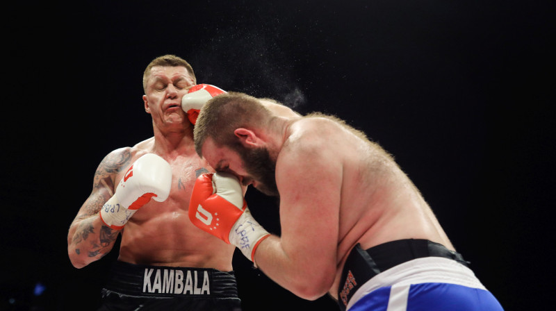 Kaspars Kambala saņem sitienu cīņā ar Aļaksandru Ņahaičuku. Foto: Dmitrijs Suļžics/f64