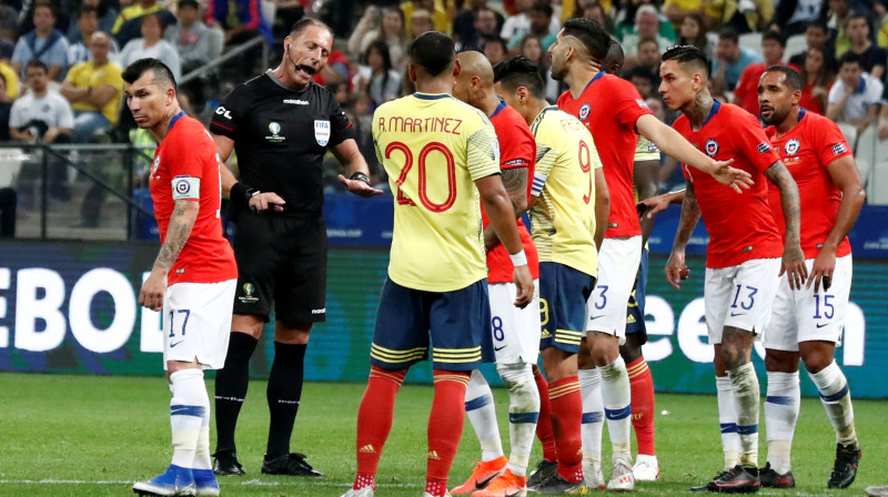 Tiesnesis Nestors Pitana veic norādījumus Kolumbijas un Čīles izlašu futbolistiem. Foto: Henry Romero/Reuters/Scanpix