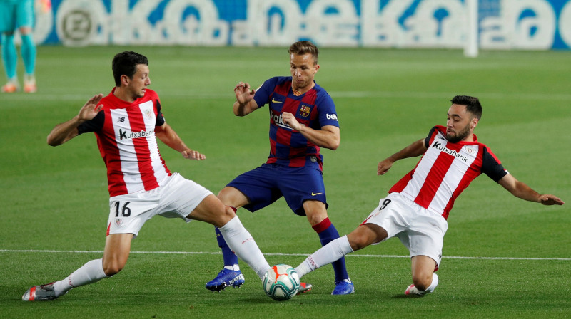 Arturs laužas starp diviem pretinieku futbolistiem. Foto: Reuters/Scanpix