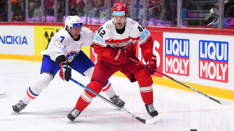 Dānijas izlases hokejists Mikels Ogārds ar ripu cīņā pret Franciju. Foto: IIHF
