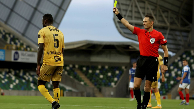 Andris Treimanis parāda dzelteno kartīti Norvēģijas "Bodø/Glimt" futbolistam. Foto: Liam McBurney/AP/Scanpix