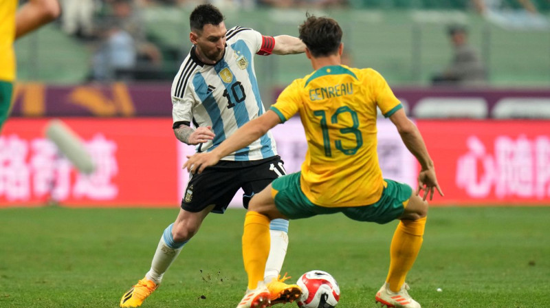 Lionels Mesi divcīņā pret austrālieti Denī Ženro. Foto: Andy Wong/AP/Scanpix