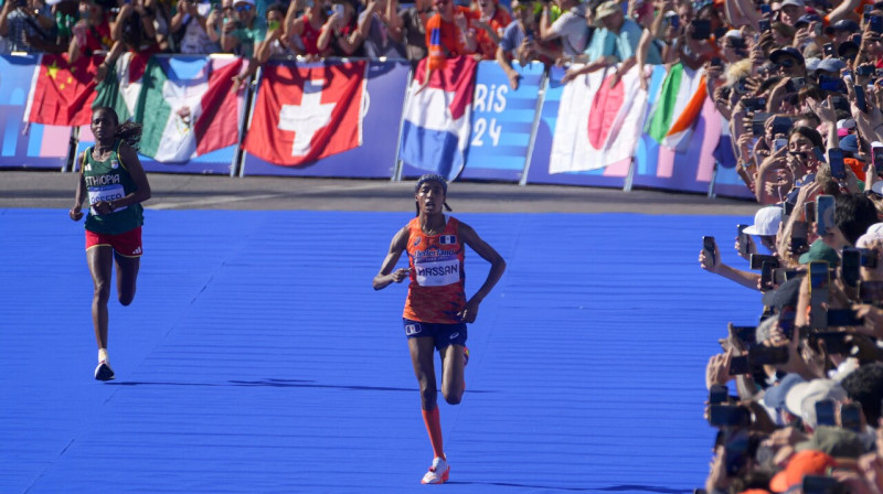 Sifana Hasana (priekšplānā) un Tigsta Asefa Parīzes olimpisko spēļu maratona finiša taisnē. Foto: Dar Yasin/AP/Scanpix