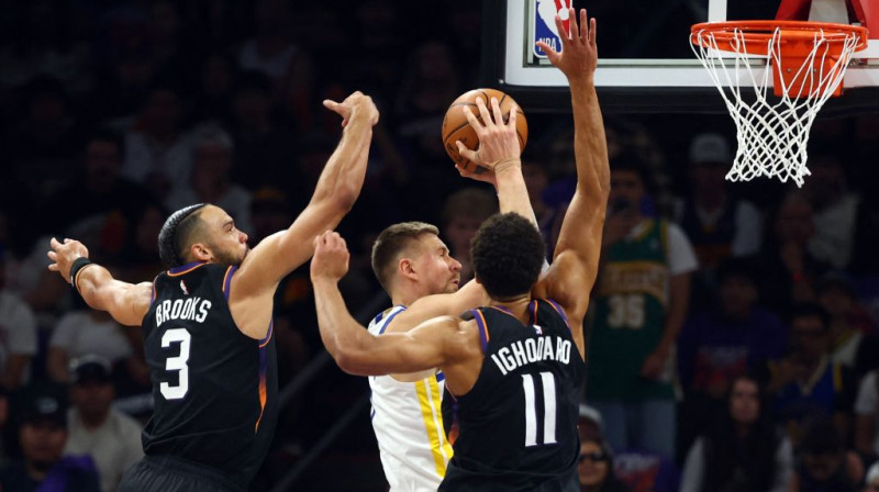 Kristaps Porziņģis starp diviem Fīniksas basketbolistiem. Foto. AP. Scanpix